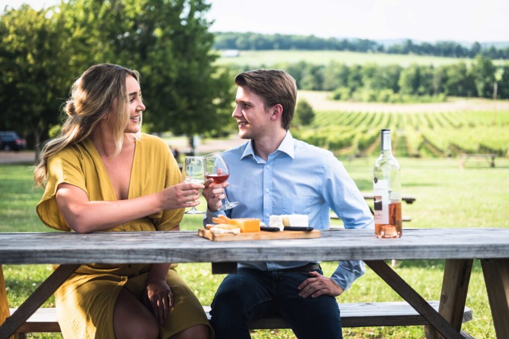 A couple enjoys wine and cheese on a picnic table overlooking a vineyard in Williamson County, Tennessee.