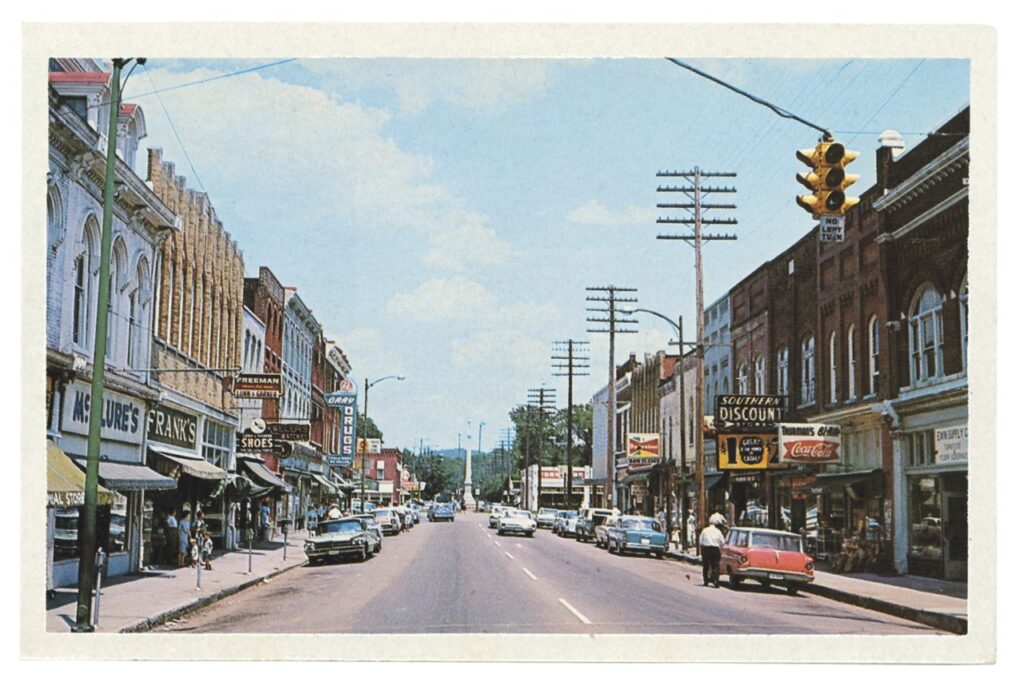 Vintage American downtown street scene with classic cars, shops, and traffic lights in Williamson County, Tennessee.