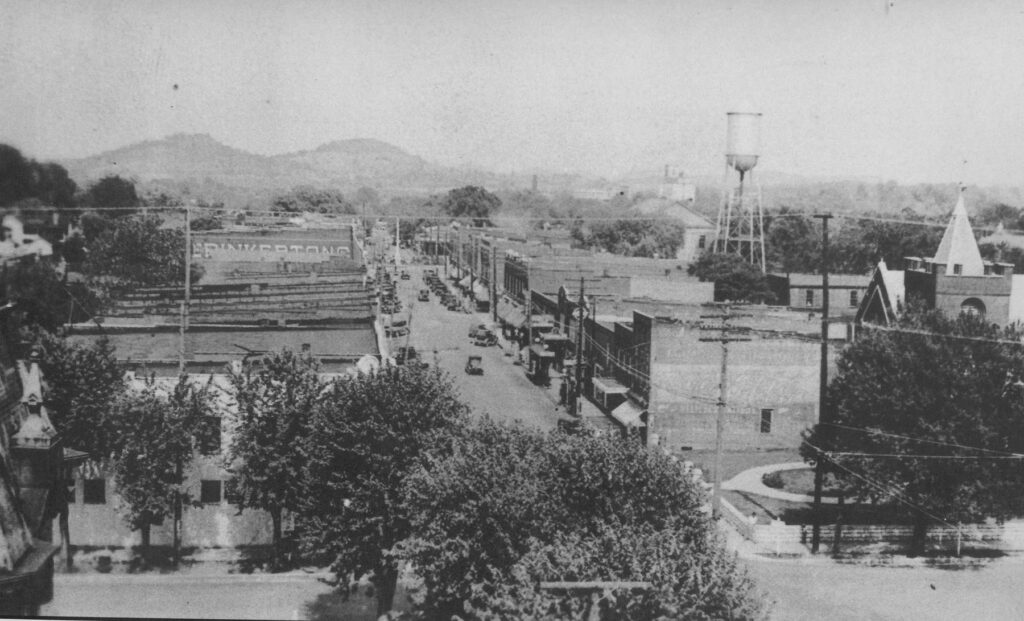 Black and white aerial view of a small town with buildings, trees, and a water tower in Williamson County, Tennessee.
