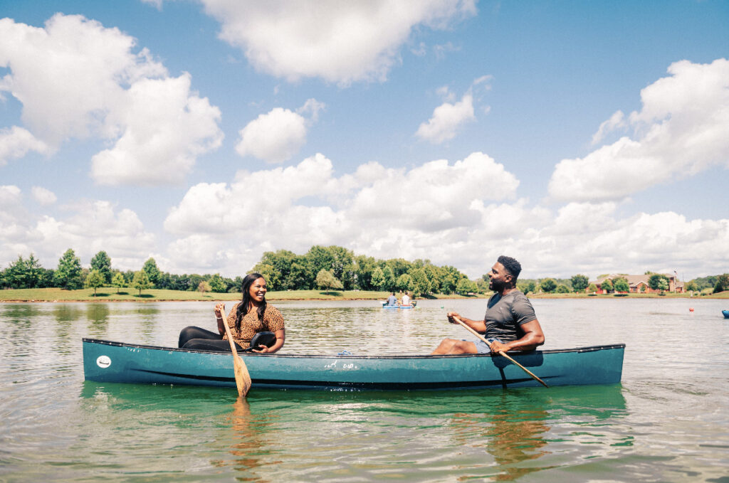 Two people enjoying a peaceful canoe ride on a calm lake under a cloudy sky in Williamson County, Tennessee.