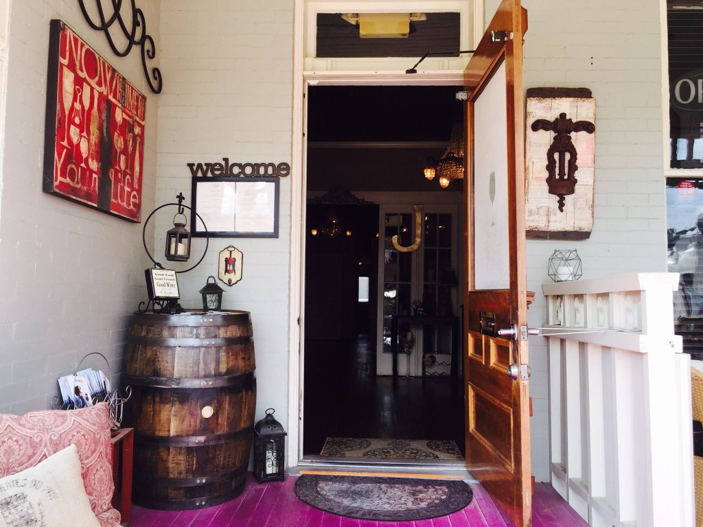 A charming entrance with a wooden door, wine barrel, and colorful wall art in Williamson County, Tennessee.