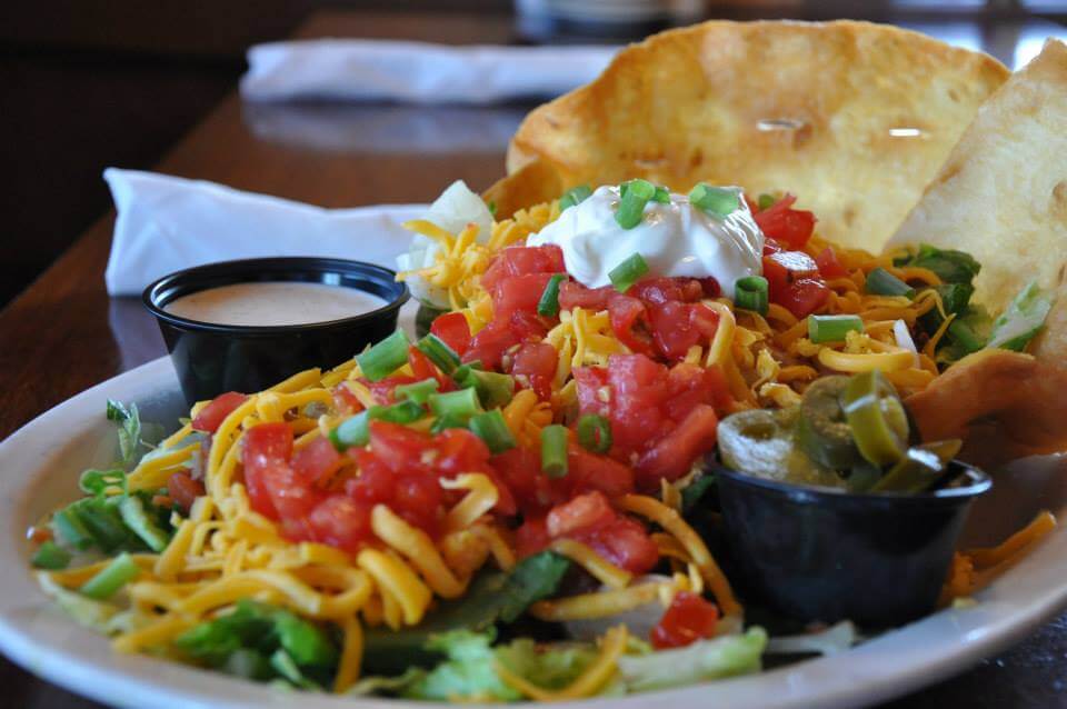 A colorful Mexican salad with tortilla chips, topped with sour cream and green onions in Williamson County, Tennessee.