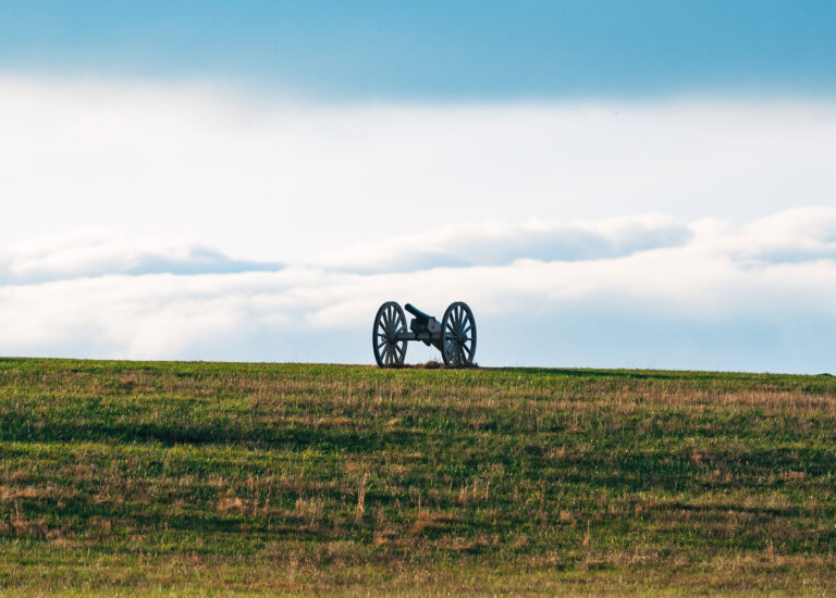 A cannon on wheels sits atop a grassy hill under a cloudy sky in Williamson County, Tennessee.