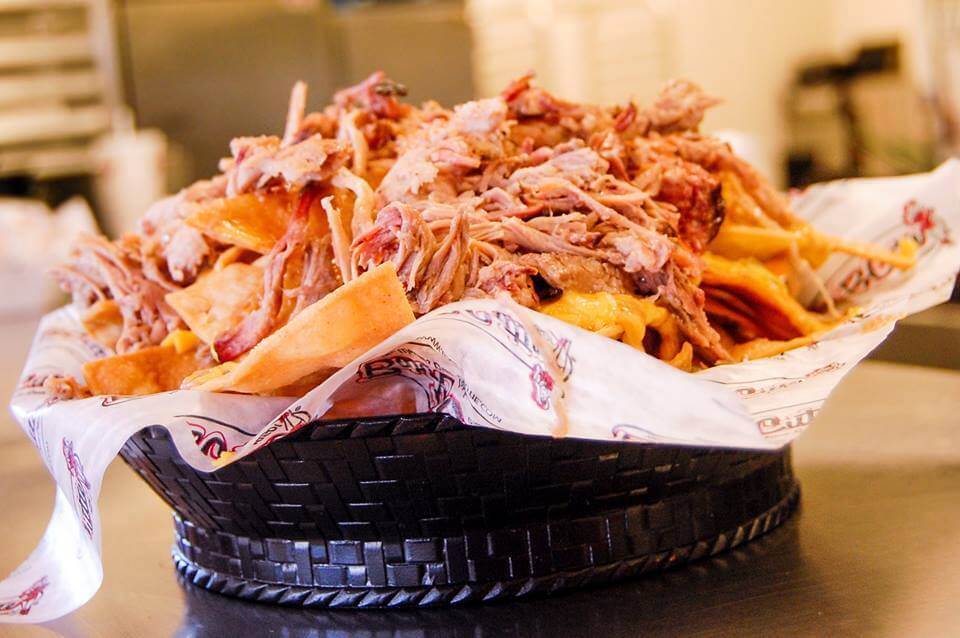 A basket of crispy tortilla chips piled high with shredded pork and melted cheese in Williamson County, Tennessee.
