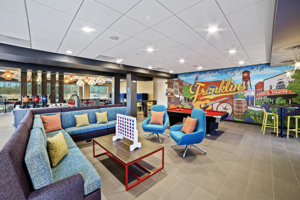 A colorful, modern lounge area with a mural, pool table, and comfortable seating in Williamson County, Tennessee.