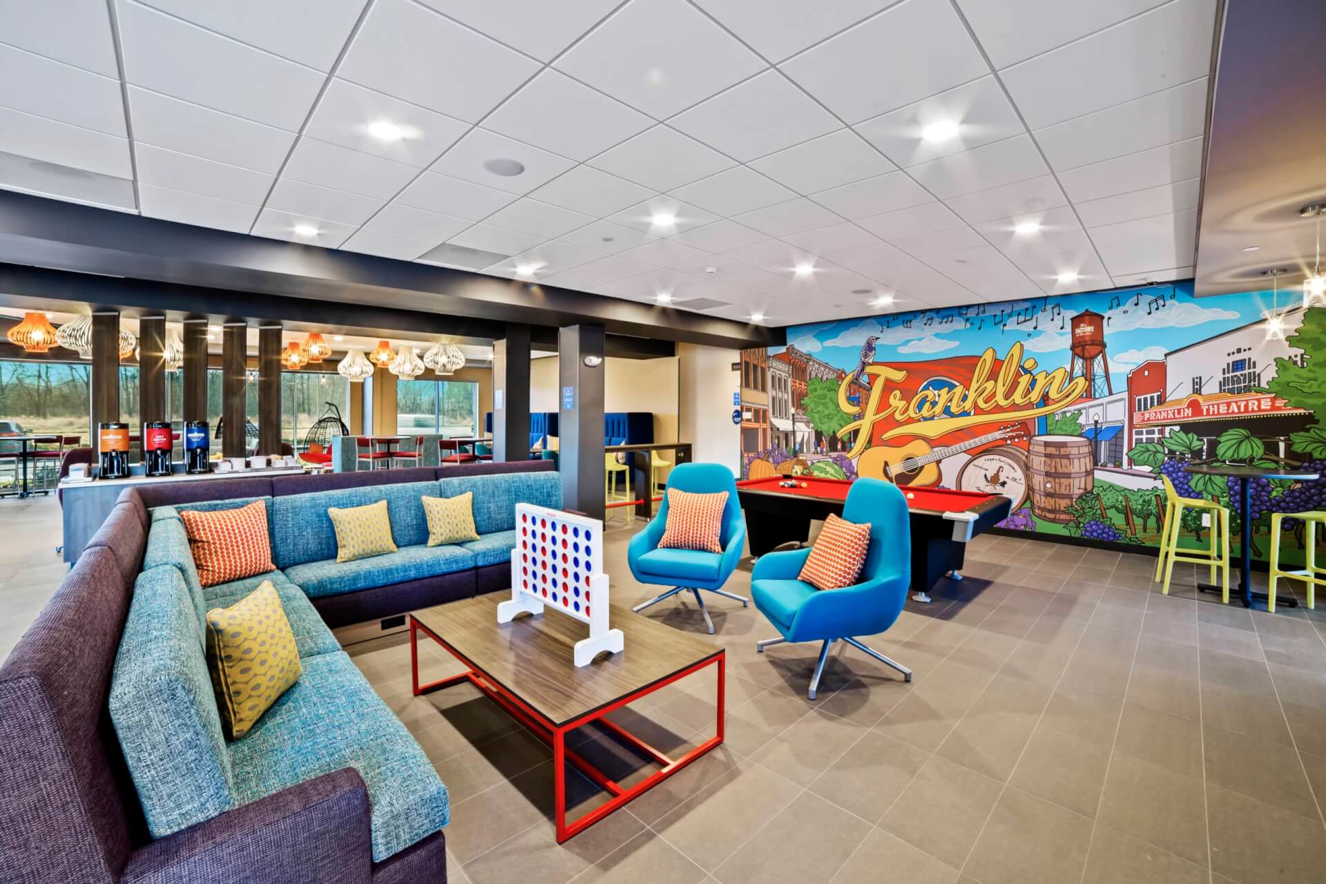 A colorful, modern lounge area with a mural, pool table, and comfortable seating in Williamson County, Tennessee.