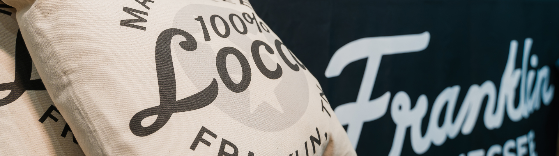 Two white pillows with '100% Local' text and a black banner with 'Franklin' script logo in Williamson County, Tennessee.