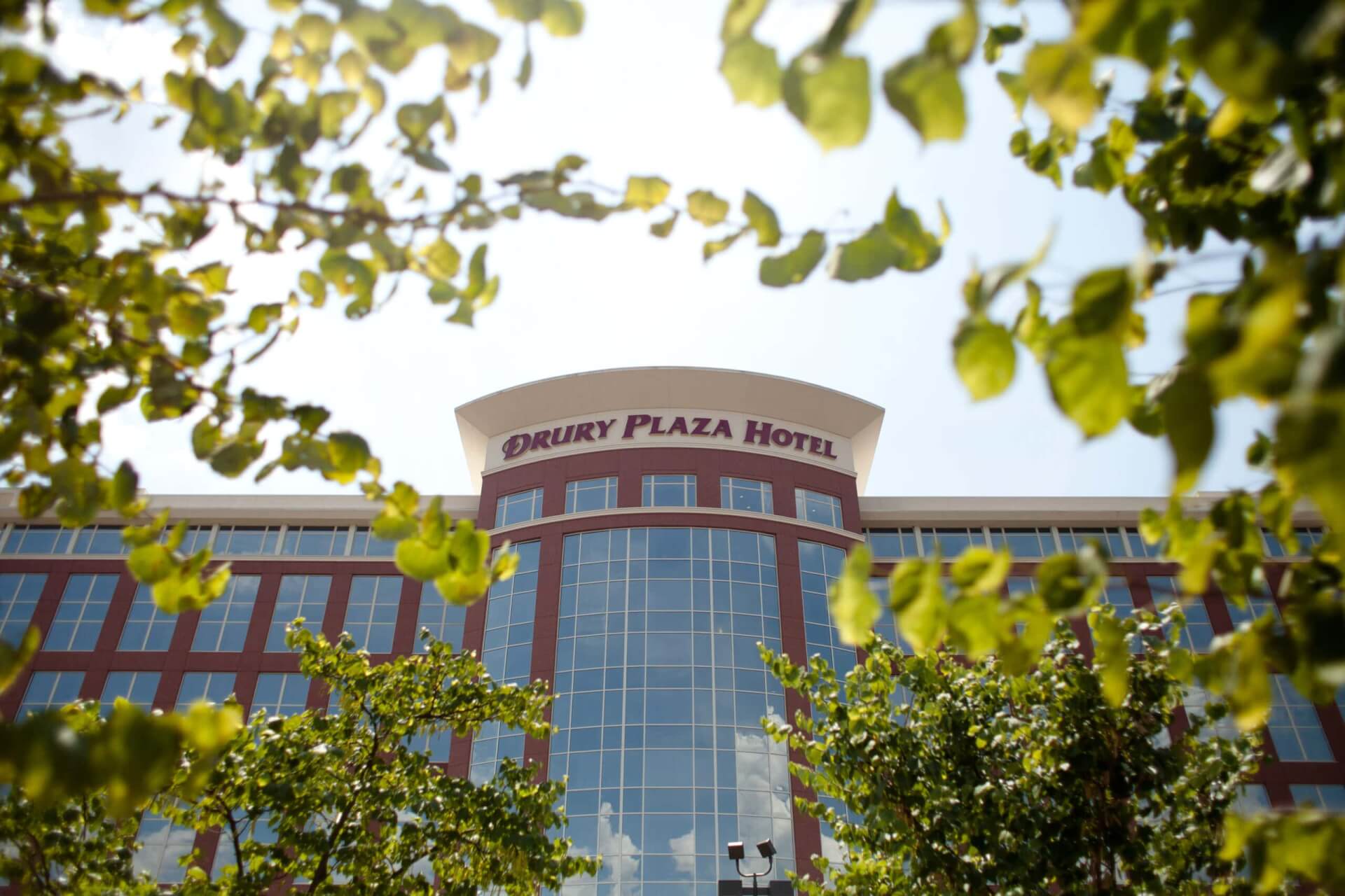 A modern hotel building with a curved glass facade and red brick accents in Williamson County, Tennessee.
