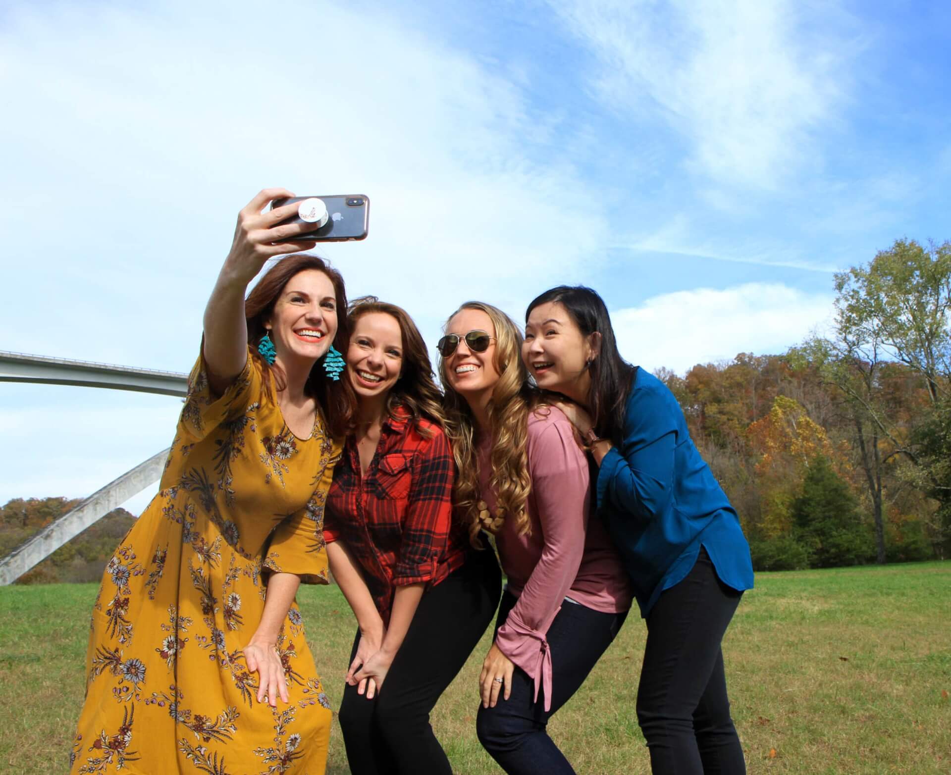 Four women in colorful outfits take a group selfie outdoors on a sunny day in Williamson County, Tennessee.