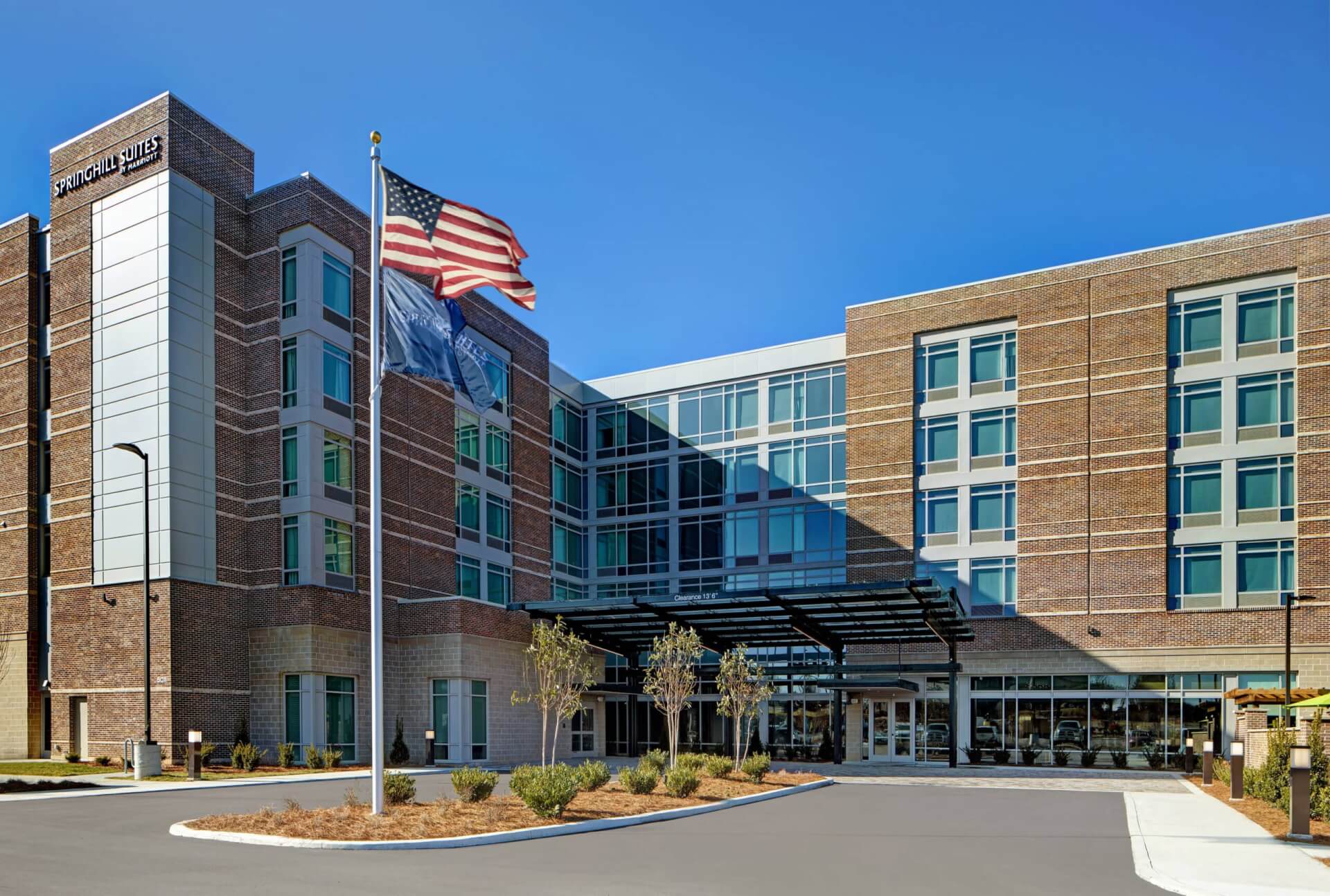 Modern hotel with brick facade, glass windows, and American flag flying high in Williamson County, Tennessee.