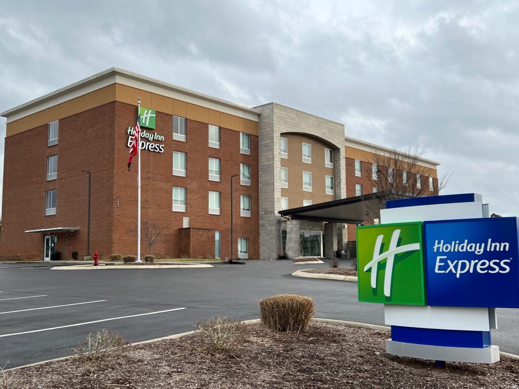 A Holiday Inn Express hotel with a green and blue sign stands in a parking lot in Williamson County, Tennessee.