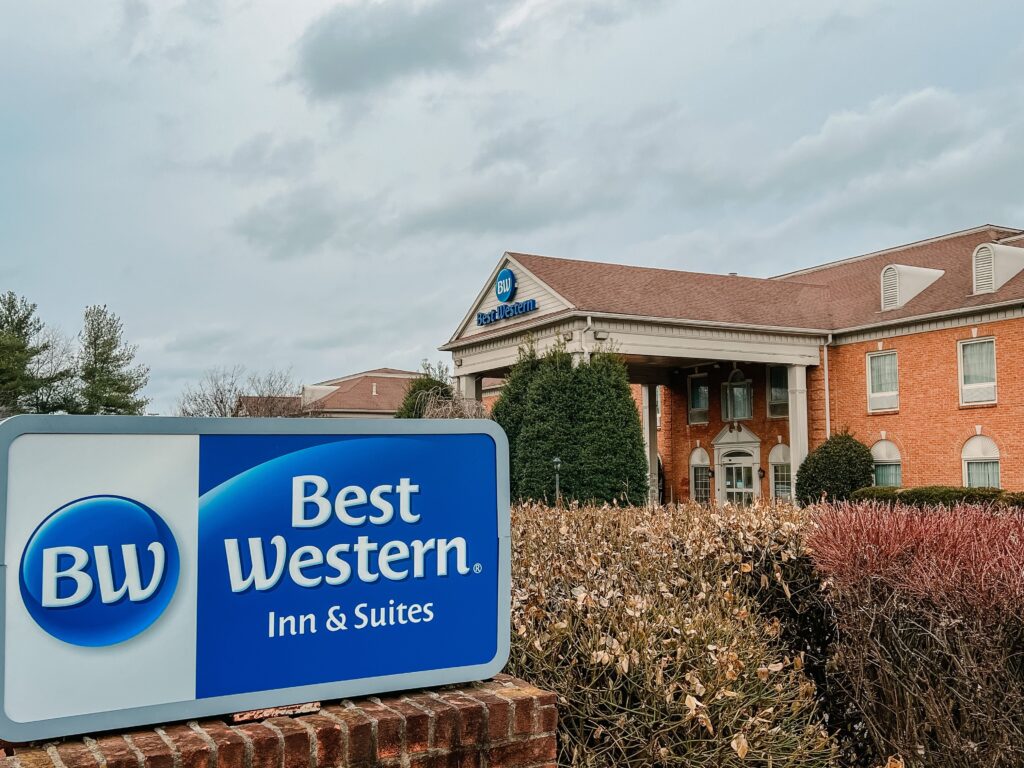 A Best Western hotel sign stands in front of a large brick building with a red roof in Williamson County, Tennessee.