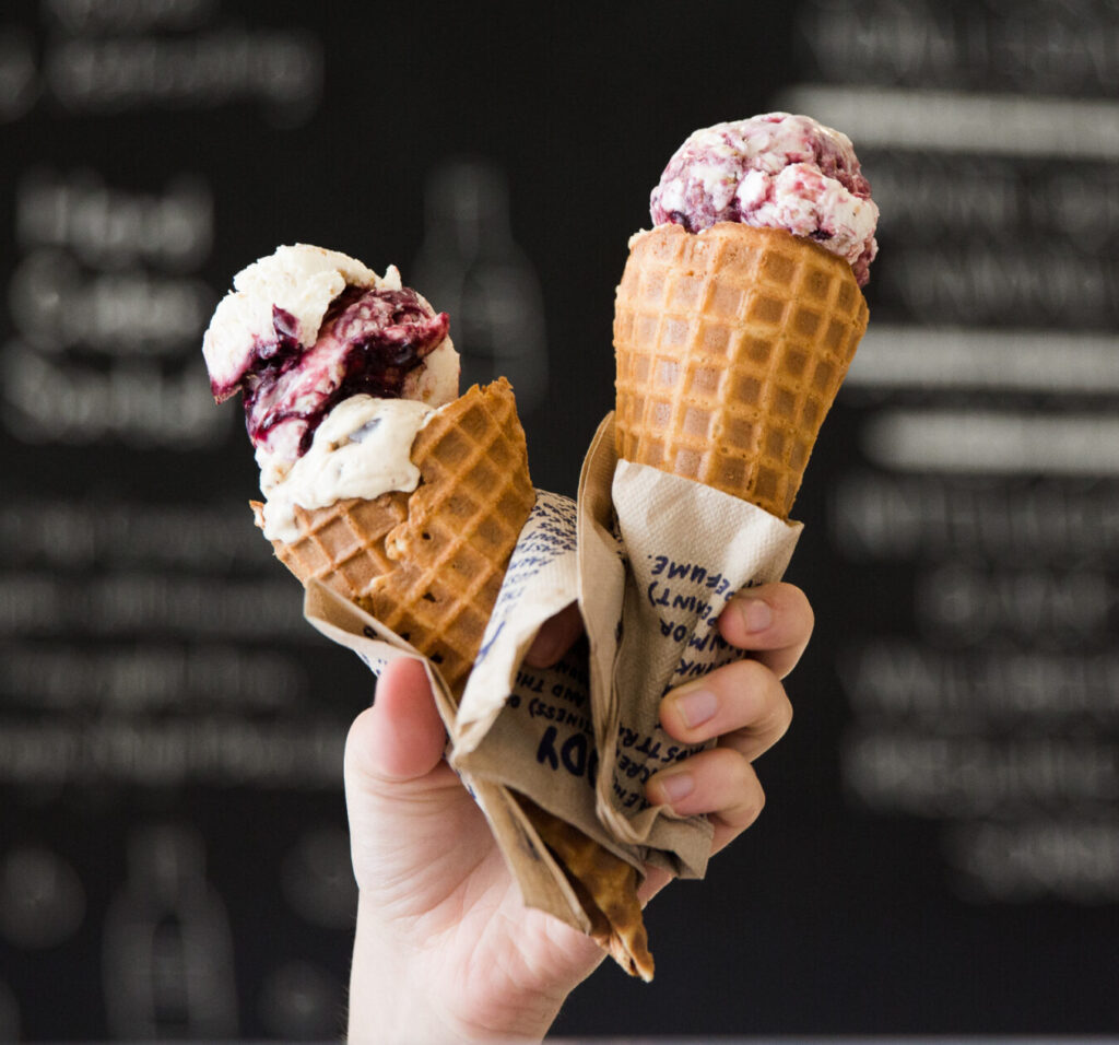 Two ice cream cones with waffle cones, one with white and berry swirl, one with pink and white swirl in Williamson County, Tennessee.