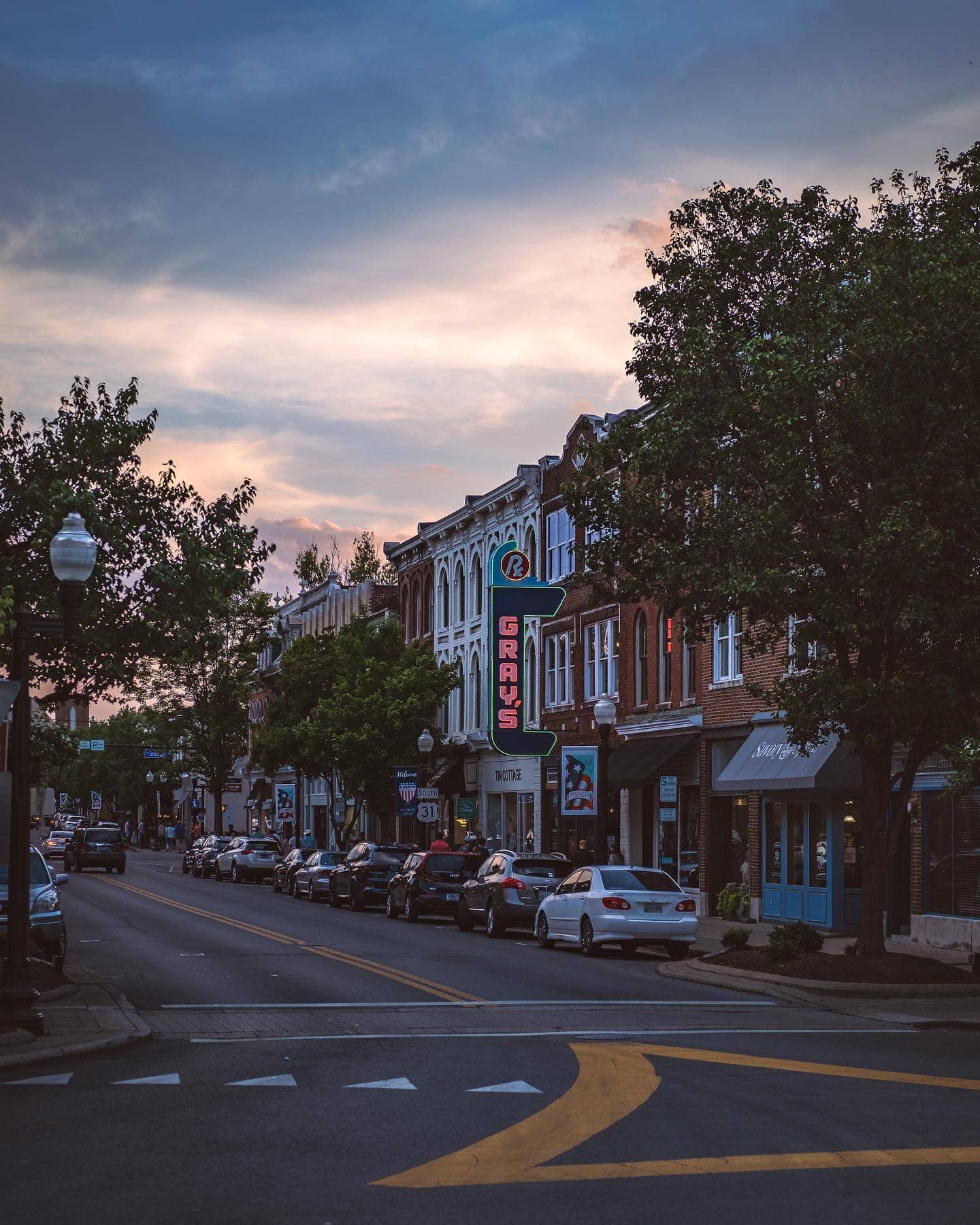Here are 5 Reasons Why Franklin, Tennessee is World-Famous A picturesque small-town street scene at dusk with vintage buildings and parked cars in Williamson County, Tennessee.
