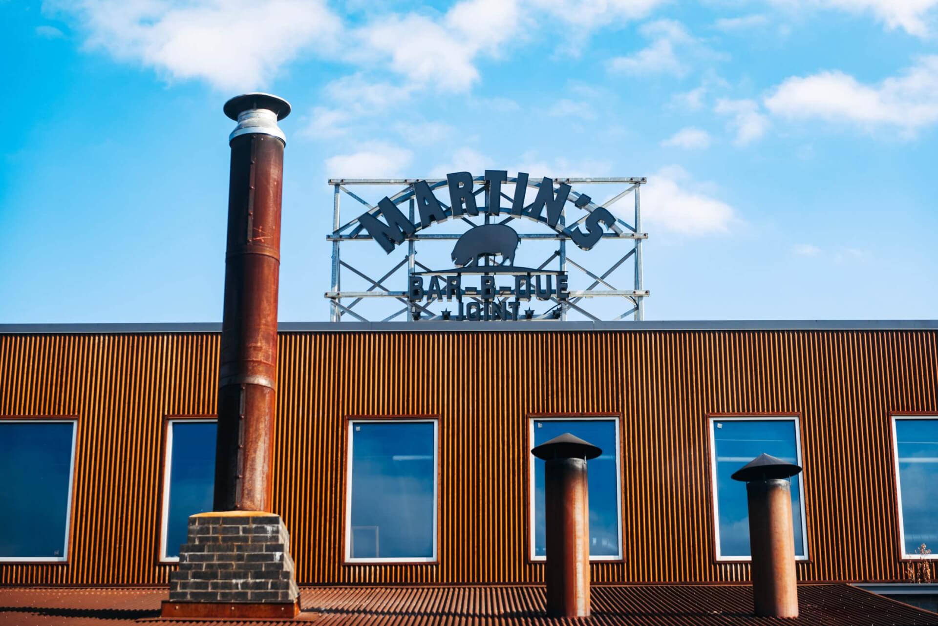 A tall brick chimney rises from the roof of a wooden building with large windows in Williamson County, Tennessee.