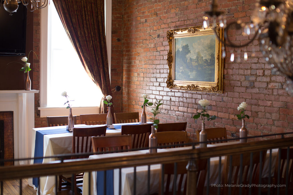 A rustic dining room with exposed brick walls, wooden tables, and floral centerpieces in Williamson County, Tennessee.