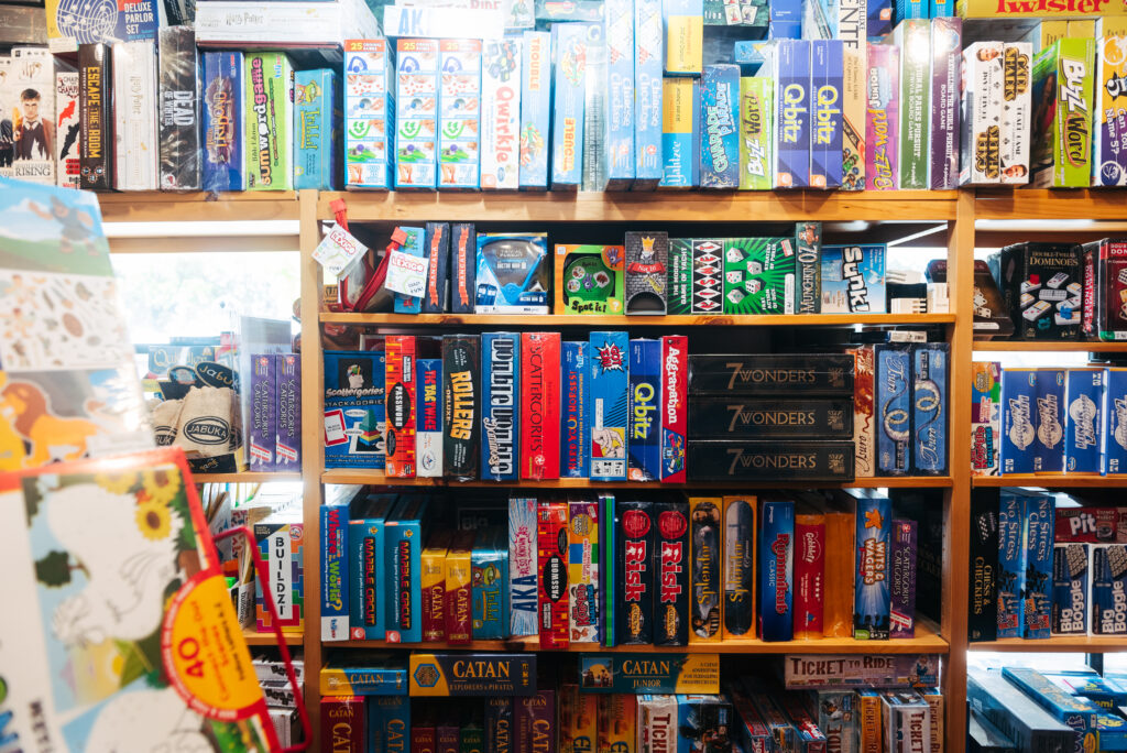 A colorful display of board games and puzzles fills wooden shelves in a store in Williamson County, Tennessee.