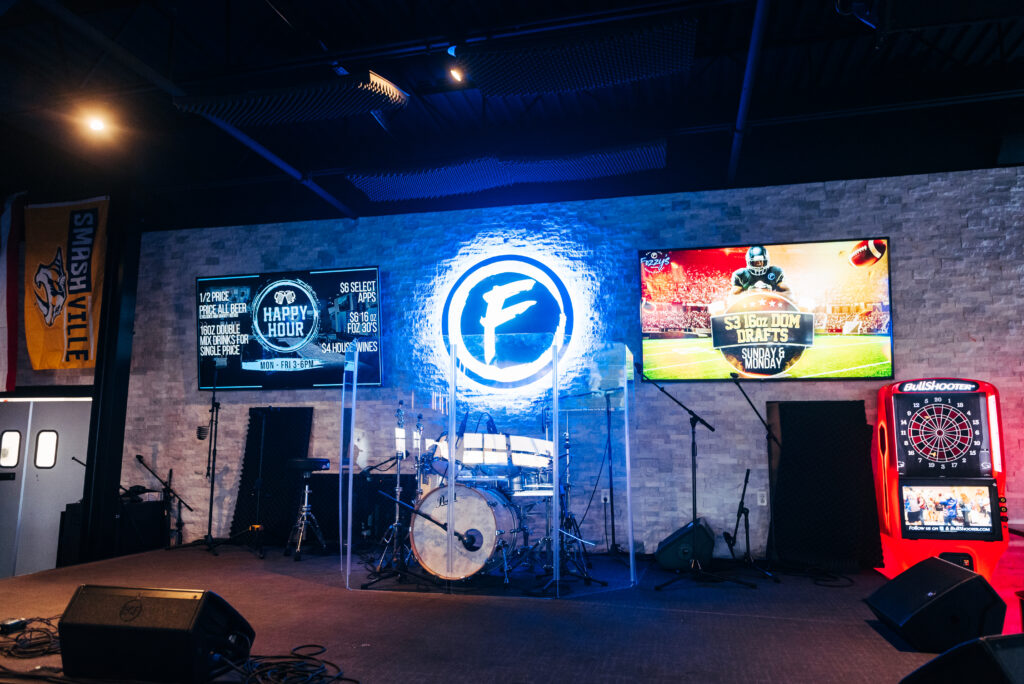 A stage with musical instruments, neon signs, and sports-themed decorations in Williamson County, Tennessee.