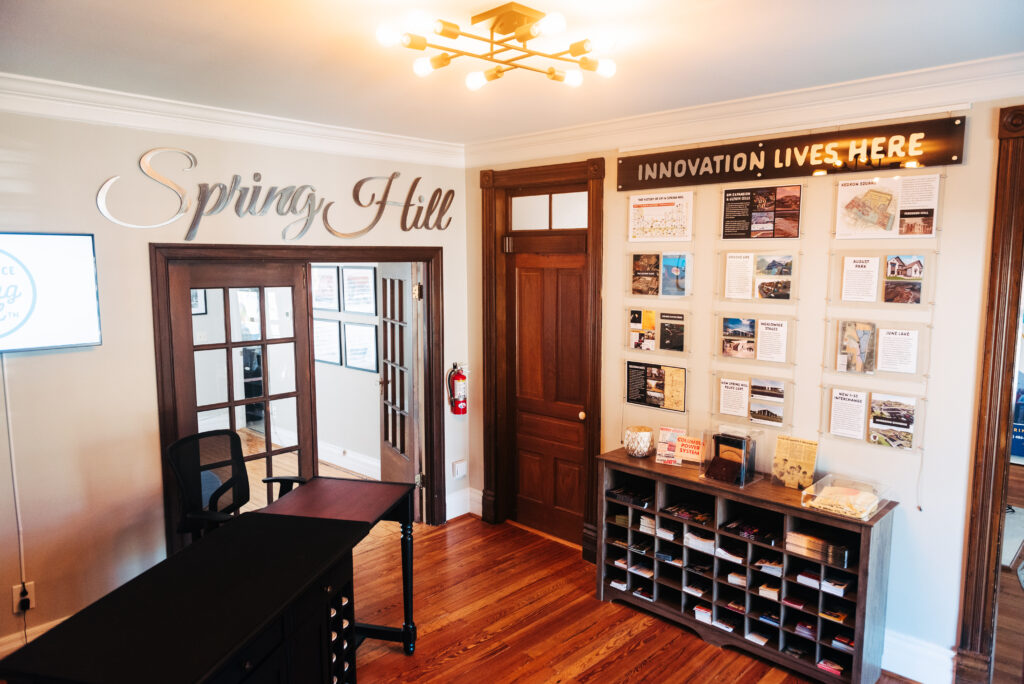 A modern office reception area with a wooden desk, bookshelves, and a wall of framed pictures in Williamson County, Tennessee.