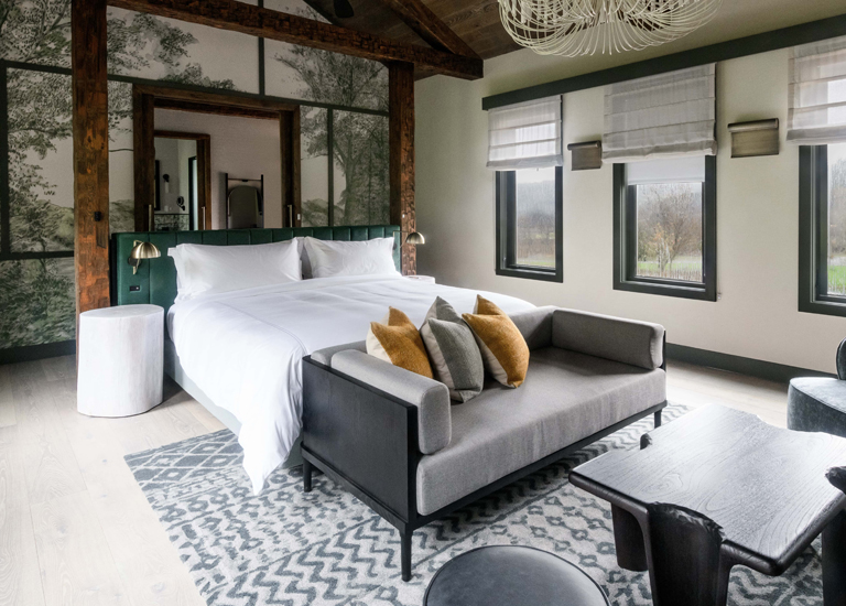 A modern bedroom with a large bed, plush sofa, and rustic-chic decor in Williamson County, Tennessee.