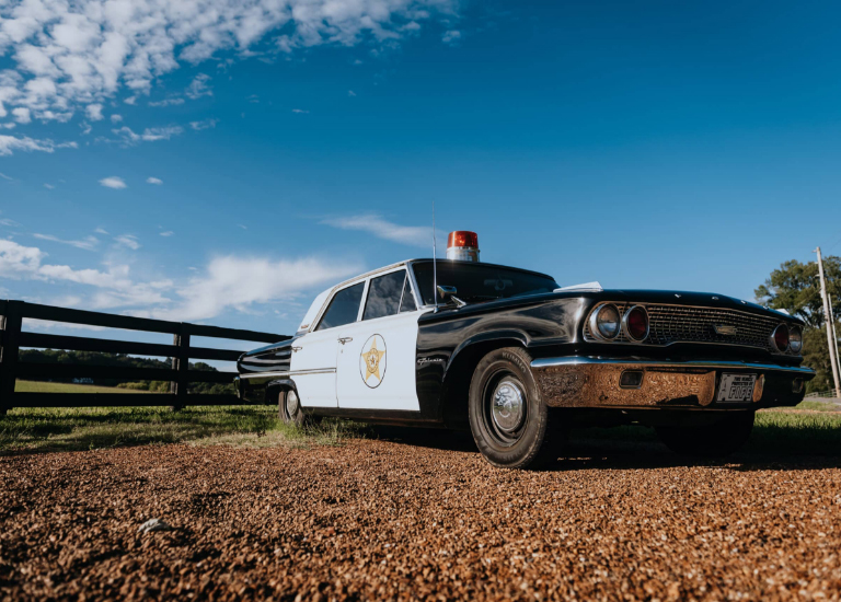 A classic black and white police cruiser with a sheriff's star parked on a dirt road in Williamson County, Tennessee.