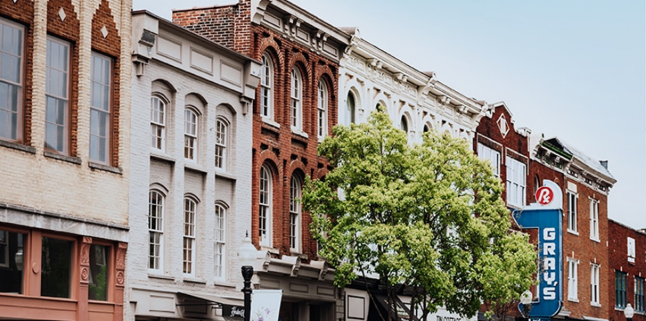 A row of colorful brick buildings with arched windows and a tree in front in Williamson County, Tennessee.