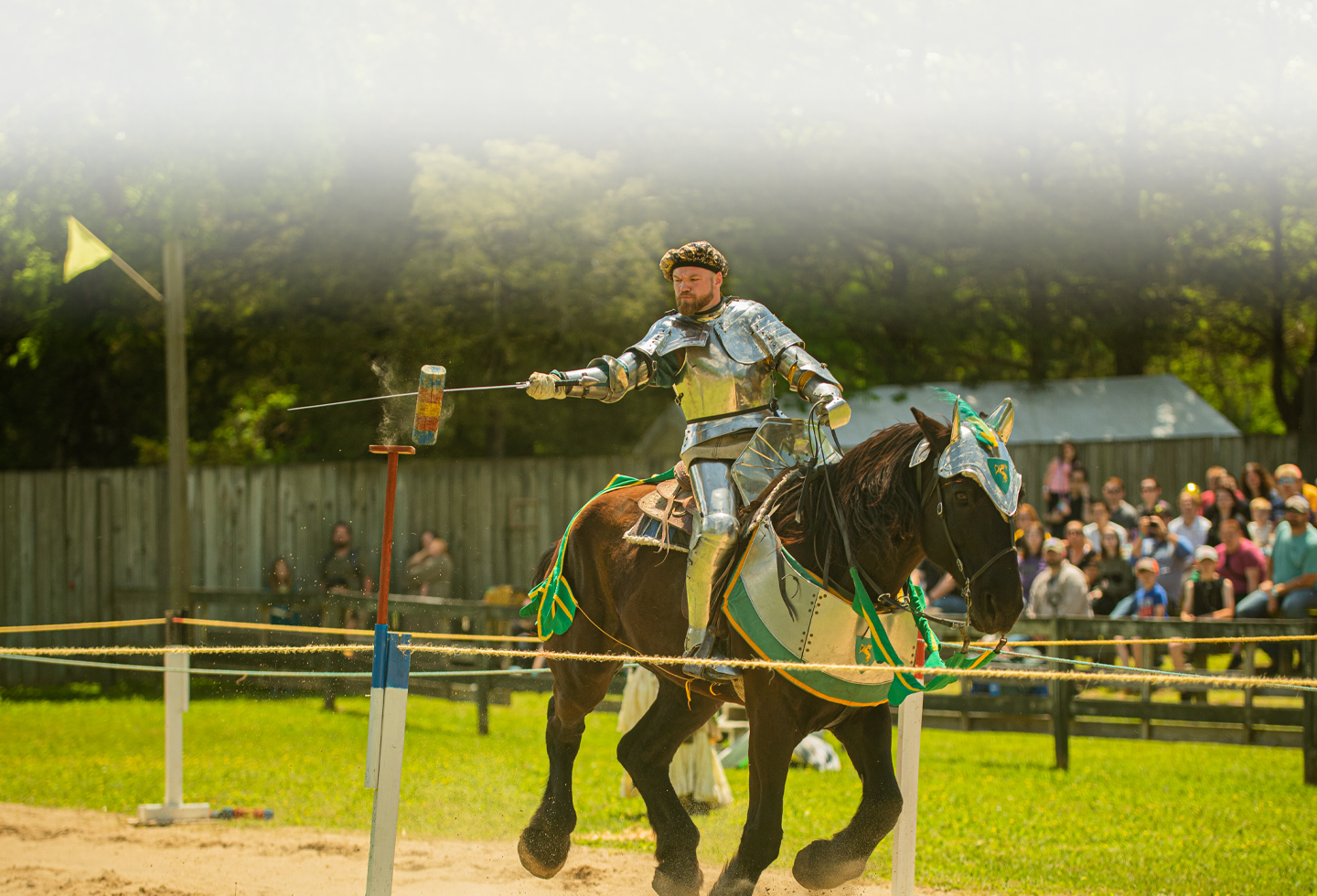 A knight in full armor rides a horse, holding a lance and aiming at a target during a jousting tournament in Williamson County, Tennessee.