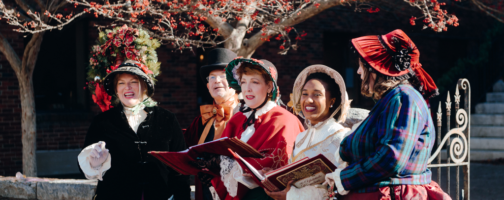 A group of five women dressed in Victorian-era costumes sing carols outdoors in Williamson County, Tennessee.