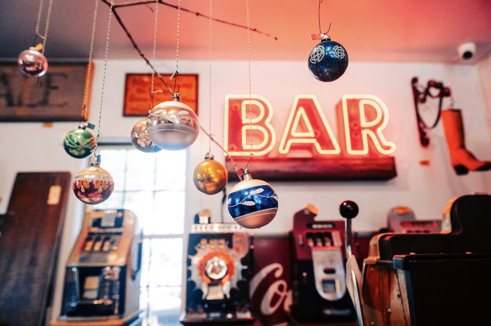 Vintage bar with neon sign, hanging ornaments, slot machines, and antique decor in Williamson County, Tennessee.