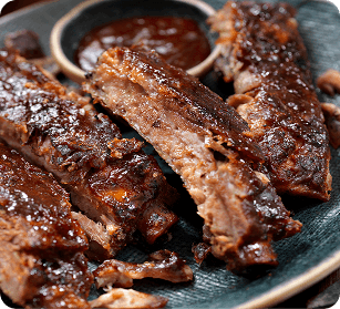 The Franklin Rodeo A plate of succulent, saucy baby back ribs with a side of barbecue sauce in Williamson County, Tennessee.