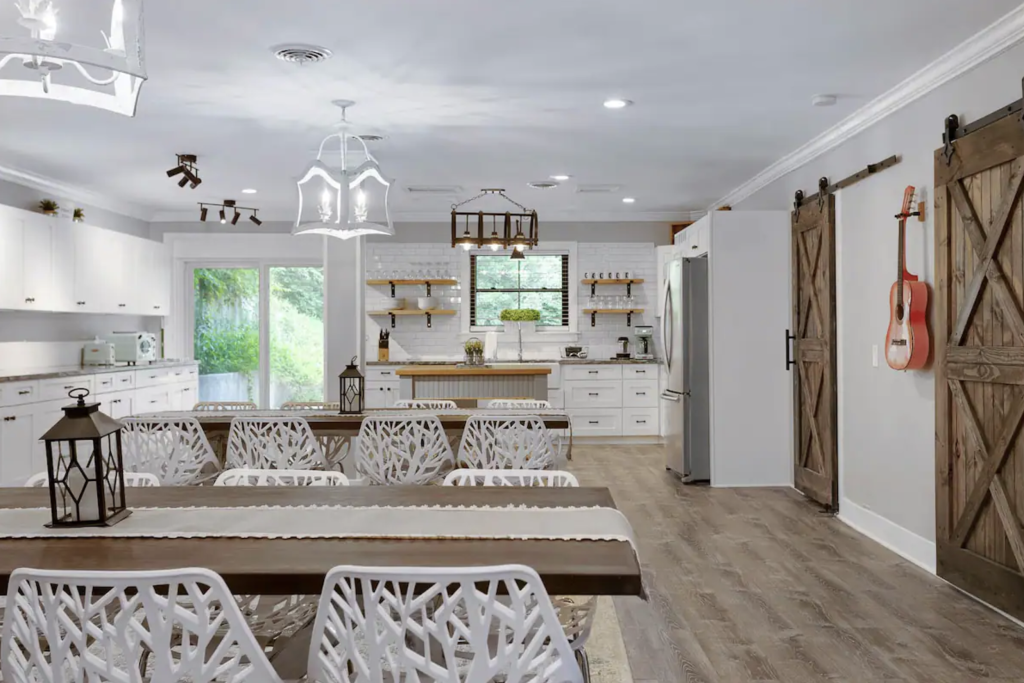 A modern kitchen with white cabinets, a wooden dining table, and unique white chairs in Williamson County, Tennessee.