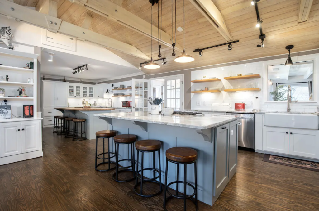 Modern kitchen with white cabinets, blue island, wooden floors, and pendant lights in Williamson County, Tennessee.