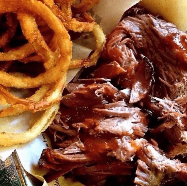 A plate of pulled pork with barbecue sauce and crispy onion rings in Williamson County, Tennessee.